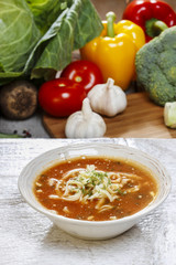 Sticker - Bowl of tomato soup and fresh vegetables on old wooden table