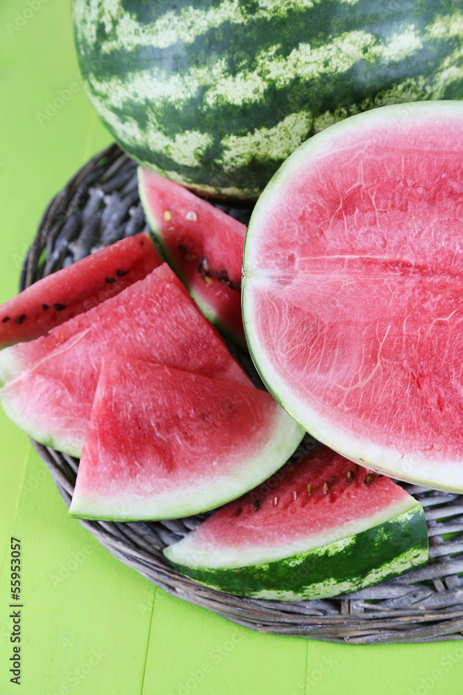 Ripe watermelons on wicker tray  on wooden table