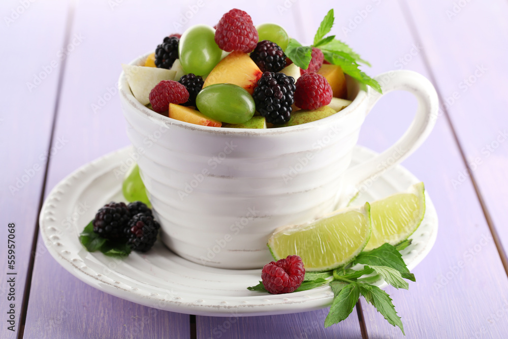 Fruit salad in cup on wooden table