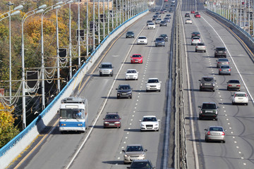 Many modern cars go on bridge at sunny day in Moscow, Russia.