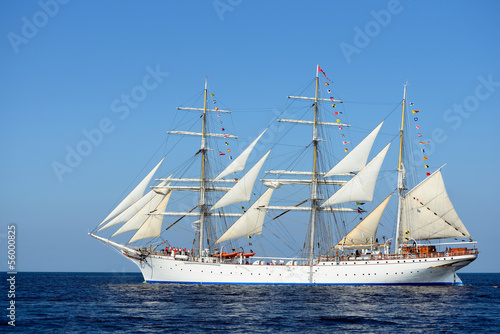 Naklejka na szybę old historical tall ship with white sails in blue sea