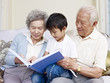 © imtmphoto - grandparents and grandson reading book together