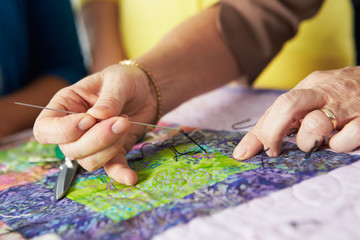 Close Up Of Woman's Hand Sewing Quilt