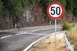 Round speed limit road sign on mountain road