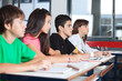 © Tyler Olson - Teenage Students Looking Away While Studying At Desk