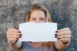 teenage girl in casual clothes holding blank sheet of paper