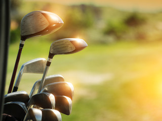 Golf clubs drivers over green field background