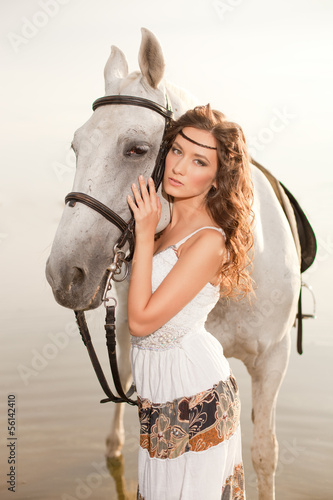 Naklejka dekoracyjna Young woman on a horse. Horseback rider, woman riding horse on b