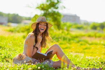 girl with book sitting on grass