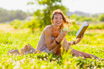 girl with book sitting on grass