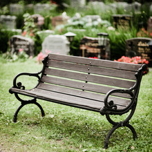 Empty Old Wooden Bench In Cemetery