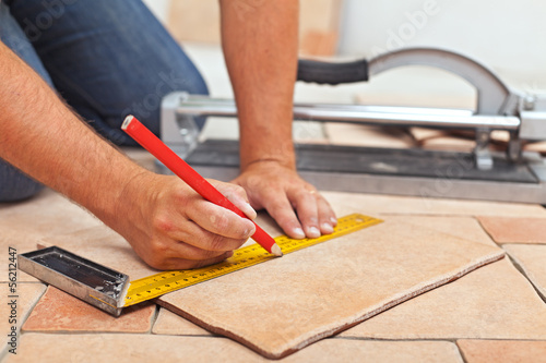 Fotografía Laying ceramic floor tiles - man hands closeup