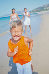 Cute boy with sister and mother on the beach