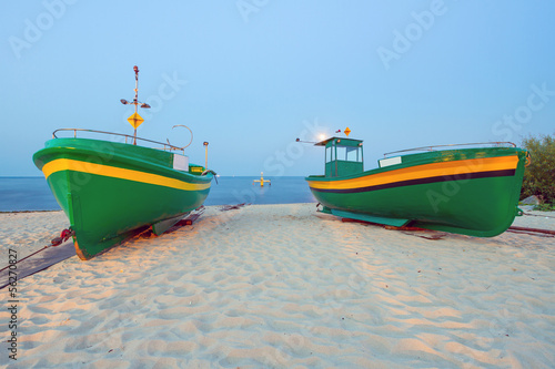 Fototapeta na wymiar Green fishing boats on the beach of Baltic sea, Poland