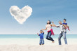 © Creativa Images - Asian family jumping under heart cloud