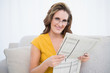© lightwavemedia - Happy woman wearing glasses holding newspaper