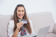 © lightwavemedia - Smiling young model using her credit card to buy online