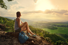 Girl Sits On The Edge Of The Cliff And Looking At The Sun
