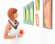 © Daco - woman admiring paintings in an art gallery