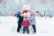 © spass - Children building snowman in garden