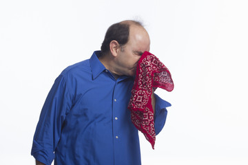 Man sneezing into handkerchief, horizontal