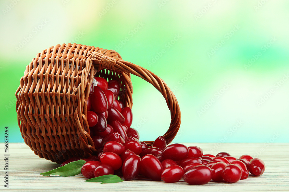 Fresh cornel berries in basket on wooden table