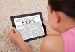 Young Woman Reading A News Article On Digital Tablet