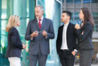 © Minerva Studio - Group of business people stood outside building