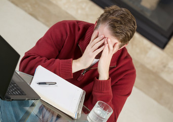 Mature man showing stress while working from home