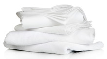 Stack Of Clean Bedding Sheets And Towels Isolated On White