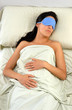 Mujer durmiendo con mascarilla tapa ojos.