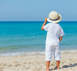 Wall Mural - Boy with hat on the beach