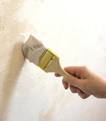 Woman's hand with brush painting wall repair vertical photo