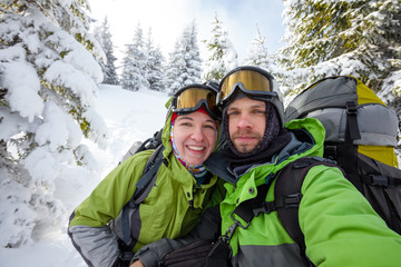 Wall Mural - Two funnny hikers posing at camera in winter mountains