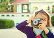 Little girl photographer taking  picture using vintage film camera