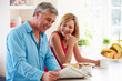 © Monkey Business - Middle Aged Couple Having Breakfast In Kitchen Together