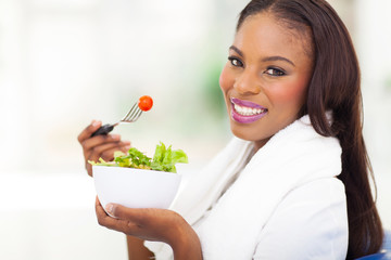 african american woman eating fresh green salad