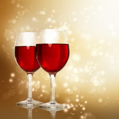 Glasses of Red Wine on Sparkling Golden Background