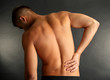 © Africa Studio - Young man with back pain on grey background