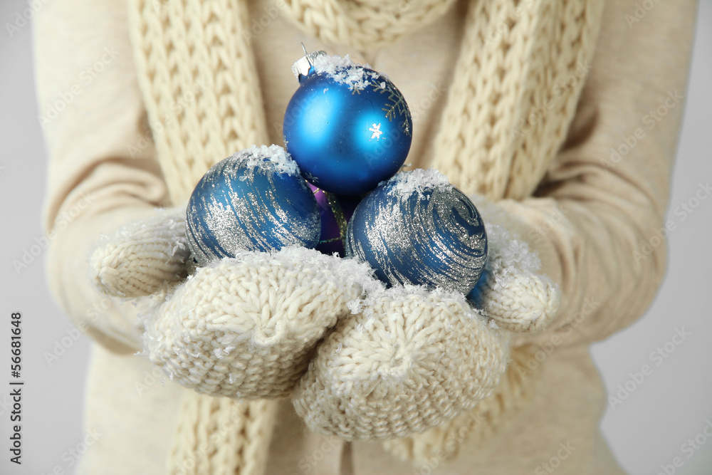 Female hands  in mittens Christmas tree balls,