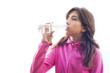 Young woman drinking water from a bottle wearing a pink jacket