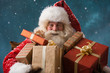 © Milles Studio - Photo of happy Santa Claus outdoors in snowfall carrying gifts t