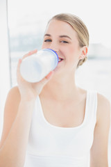 Wall Mural - Happy sporty woman drinking water from her flask