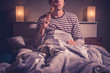 © LoloStock - Young man is sitting in bed and eating chicken