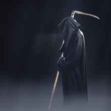 Death With Scythe Standing In The Fog At Night