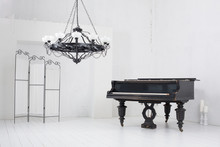 Light Room With A Piano, A Folding Screen And A Chandelier