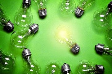 Wall Mural - Idea concept with light bulbs on green background.