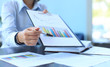 © ty - Close-up of graphs and charts analyzed by businessman