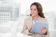 © lightwavemedia - Beautiful happy businesswoman using tablet