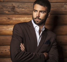 Wall Mural - Young beautiful fashionable man against wooden wall.